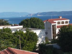 a white building with a red roof and the water at Apartman Mare in Dramalj