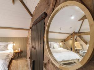 ein Schlafzimmer mit großem Spiegel und Bett in der Unterkunft Elm Cottage - Fold Yards in Belper
