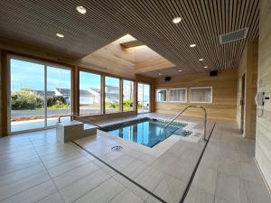 una piscina en una casa con una habitación grande con ventanas en The Whaler, en Newport