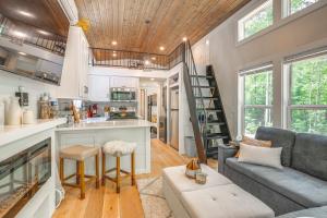 a living room with a couch and a kitchen at Monteagle Cabin with Swim Spa, Sauna and Fire Pit! in Monteagle