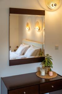 1 dormitorio con espejo grande encima de la cama en Aiora Suites, en Sivota
