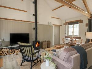 ein Wohnzimmer mit Couch und Kamin in der Unterkunft Oak Cottage - Fold Yards in Belper