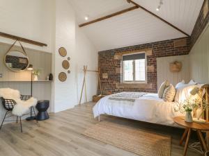 ein Schlafzimmer mit einem großen Bett und einer Ziegelwand in der Unterkunft Oak Cottage - Fold Yards in Belper