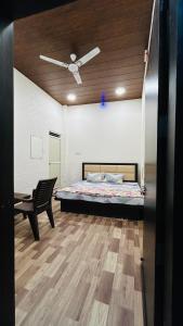 1 dormitorio con 1 cama y 1 silla en Hotel Amrit shree, en Ujjain
