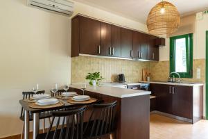 a kitchen with a table with chairs and a counter top at Aiora Suites in Sivota