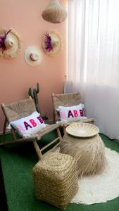 Habitación con 2 sillas y 2 reposapiés con almohadas en Bel appartement au centre gueliz, en Marrakech