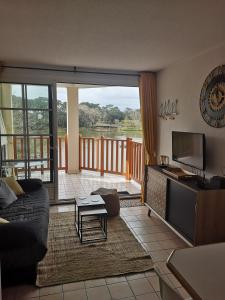 a living room with a couch and a balcony at l'orée du lac in Talmont