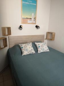 a bedroom with a bed with two pillows on it at l'orée du lac in Talmont