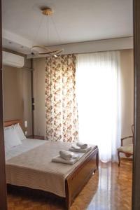 Un dormitorio con una cama y una ventana grande. en Center Proluxe Apartment, en Alexandroupoli