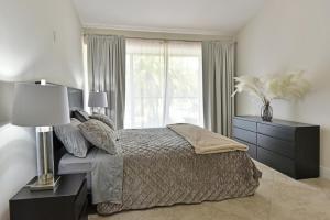 ein Schlafzimmer mit einem großen Bett und einem Fenster in der Unterkunft Cozy home with private entrance! in Wellington
