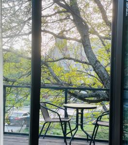 een tafel en stoelen op een veranda met een boom bij Cottage Am Museum in Mestia +33 foto's
