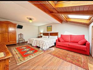 ビリャビシオサにあるHotel Palacio Carlos Iのベッドルーム1室(ベッド1台、赤いソファ付)