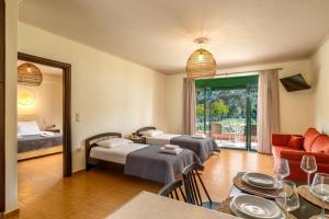a hotel room with two beds and a living room at Aiora Suites in Syvota
