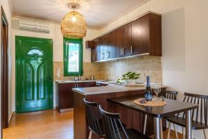 a kitchen with a green door and a table with chairs at Aiora Suites in Syvota +70 photos