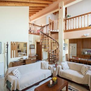 una sala de estar con 2 sofás y una escalera en Neromilos Harmony - Roussis Residence, en Nerómilos