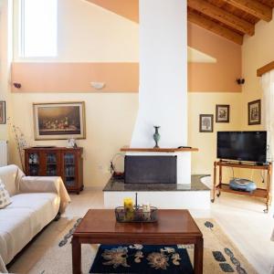 ein Wohnzimmer mit einem Sofa und einem TV in der Unterkunft Neromilos Harmony - Roussis Residence in Nerómilos