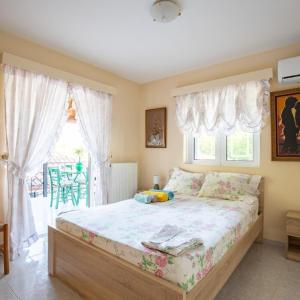 Nerómilos的住宿－Neromilos Harmony - Roussis Residence，一间卧室设有一张大床和一个窗户。