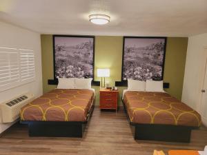 Habitación de hotel con 2 camas y 2 cuadros en la pared en Super 8 by Wyndham El Centro North, en El Centro