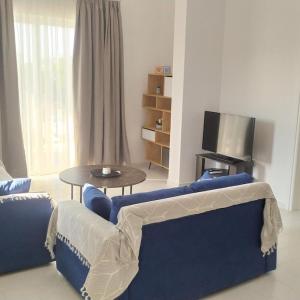 uma sala de estar com um sofá azul e uma mesa em Samos Home by the sea em Kámpos