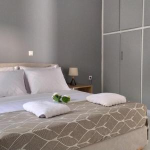 uma cama com duas almofadas e uma planta em Samos Home by the sea em Kámpos