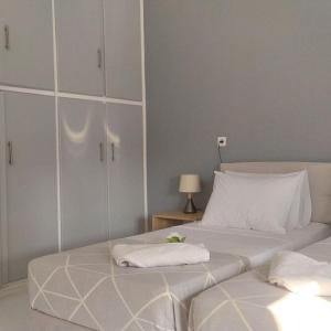 a bedroom with two beds and white cabinets at Samos Home by the sea in Kámpos