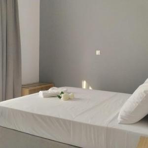 a white bed with two white towels on it at Samos Home by the sea in Kámpos