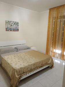 a bed in a white room with avertisement at appartamento Paestum in Paestum