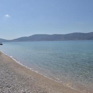 una playa con una orilla rocosa con montañas en el fondo en Salamis Beachfront House, en Salamina