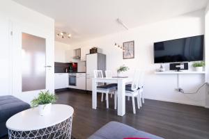ein Wohnzimmer mit einem Tisch und einer Küche in der Unterkunft Ferienpark Sierksdorf App 452 - Strandlage in Sierksdorf