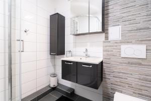 ein Bad mit einem Waschbecken, einem Spiegel und einer Dusche in der Unterkunft Ferienpark Sierksdorf App 452 - Strandlage in Sierksdorf