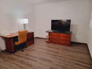 ein Büro mit einem Schreibtisch, einem TV und einem Stuhl in der Unterkunft Super 8 by Wyndham El Centro North in El Centro