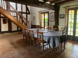 a dining room with a blue table and chairs at La Coraline in Laubressel