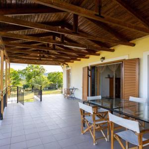 um pátio exterior com uma mesa de vidro e cadeiras em Marva Residence - comfortable 8-person retreat em Nerómilos