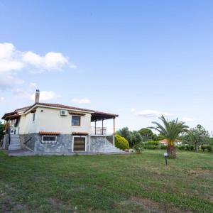 Marva Residence - comfortable 8-person retreat في Nerómilos: منزل في حقل مع ساحة عشب