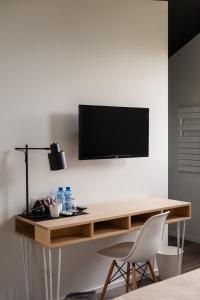a wooden desk with a television on a wall at dimensions M in Mont-Saint-Guibert