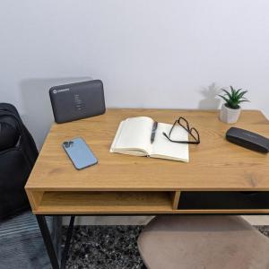 a wooden desk with a laptop and a book at Cozy Apartment in Kallithea in Athens