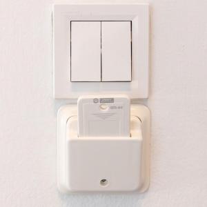 a white outlet on a wall with a picture at Cozy Apartment in Kallithea in Athens