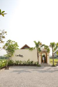 a person standing in the doorway of a building with palm trees at LAVILLAS JOGJA in Cebongan