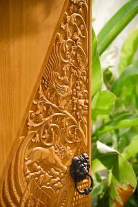 una puerta de madera con una talla de dragón en ella en LAVILLAS JOGJA en Cebongan