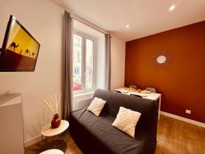a living room with a couch and a window at L'Oasis - Home Homy in Carhaix-Plouguer