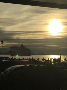 un navire de croisière dans l'eau avec un coucher de soleil dans l'établissement Goéliche hotel et appartement, à Saint-Laurent-de-l'ile d'Orleans