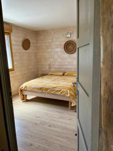 a bedroom with a bed and a wooden floor at La Poussada, maisons écologiques avec vue mer in Lapalme