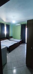a room with two beds in it with curtains at Festim hotel in Durrës +10 photos