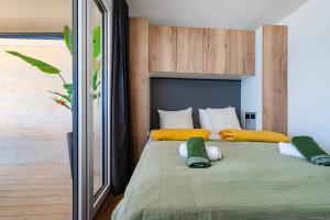 a bedroom with a large bed with yellow and white pillows at Luna Maris in Drage