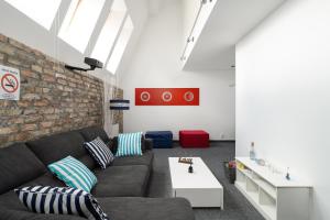 a living room with a couch and a brick wall at Sleepway Apartment - Marina in Poznań