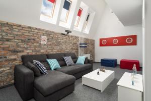 a living room with a couch and a brick wall at Sleepway Apartment - Marina in Poznań +24 photos
