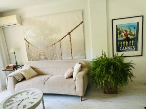 ein Wohnzimmer mit einer weißen Couch und einer Brücke in der Unterkunft Cannes, charmant 3 pièces proches plages, tout confort au calme in Cannes