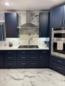 cocina con armarios azules y fogones en Huge Family House 12 Miles To Nyc4bathparking, en Belleville