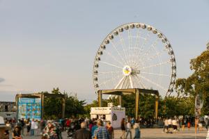 uma roda gigante num parque com uma multidão de pessoas em Sonder Le Victoria em Montreal