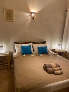 ein Schlafzimmer mit einem großen Bett mit blauen Kissen in der Unterkunft Dar Louka in Tahannaout